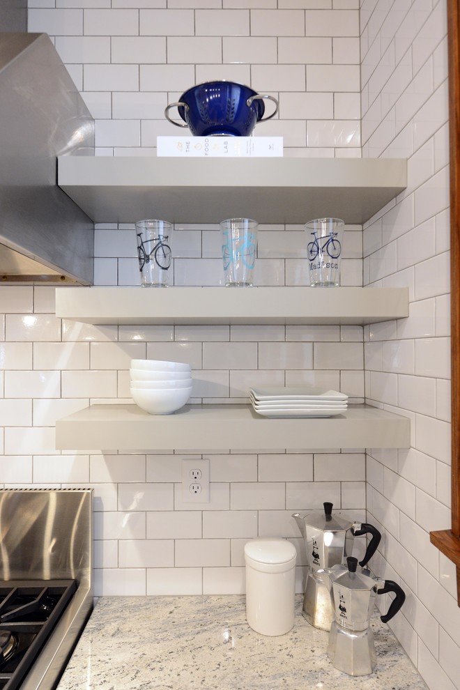 Mid-sized transitional light wood floor and brown floor enclosed kitchen photo with a farmhouse sink, shaker cabinets, gray cabinets, wood countertops, white backsplash, porcelain backsplash, stainless steel appliances, an island and brown countertops