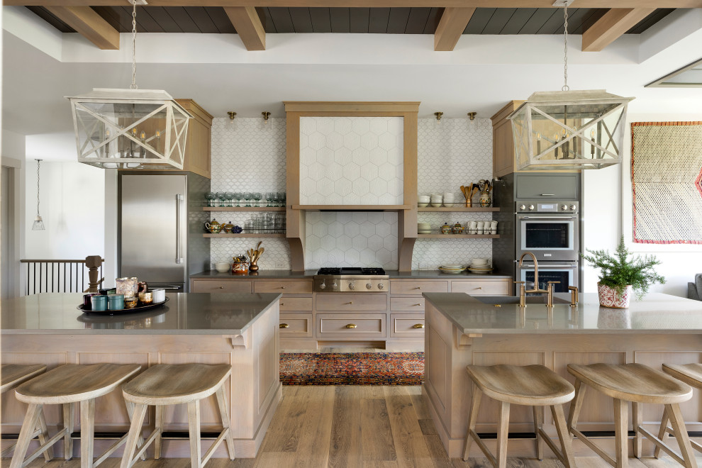 Inspiration for a country galley open plan kitchen in Minneapolis with a farmhouse sink, shaker cabinets, light wood cabinets, white splashback, mosaic tile splashback, stainless steel appliances, medium hardwood floors, multiple islands, brown floor, grey benchtop, exposed beam, timber and recessed.