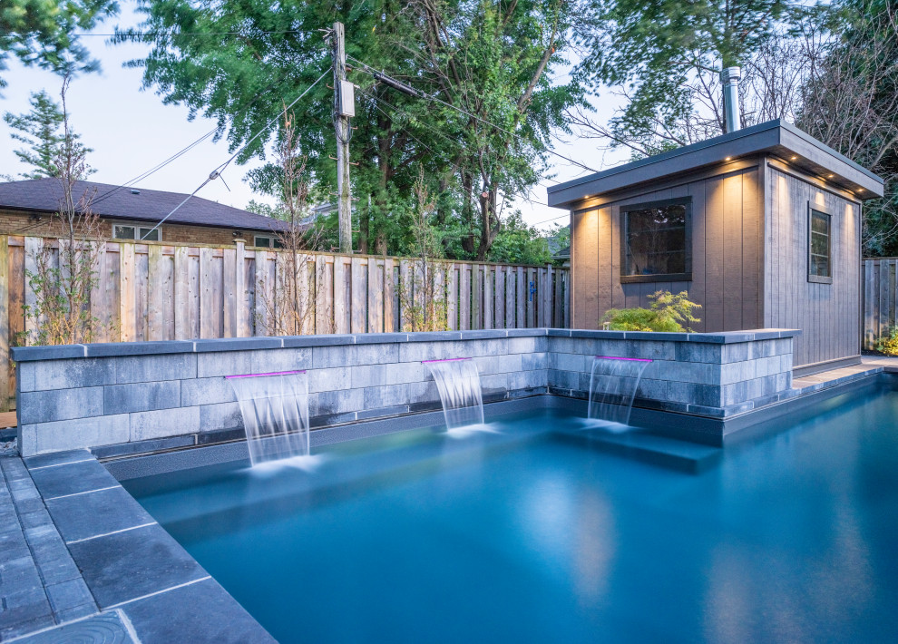 Inspiration for a mid-sized transitional backyard concrete paver and l-shaped lap pool fountain remodel in Toronto