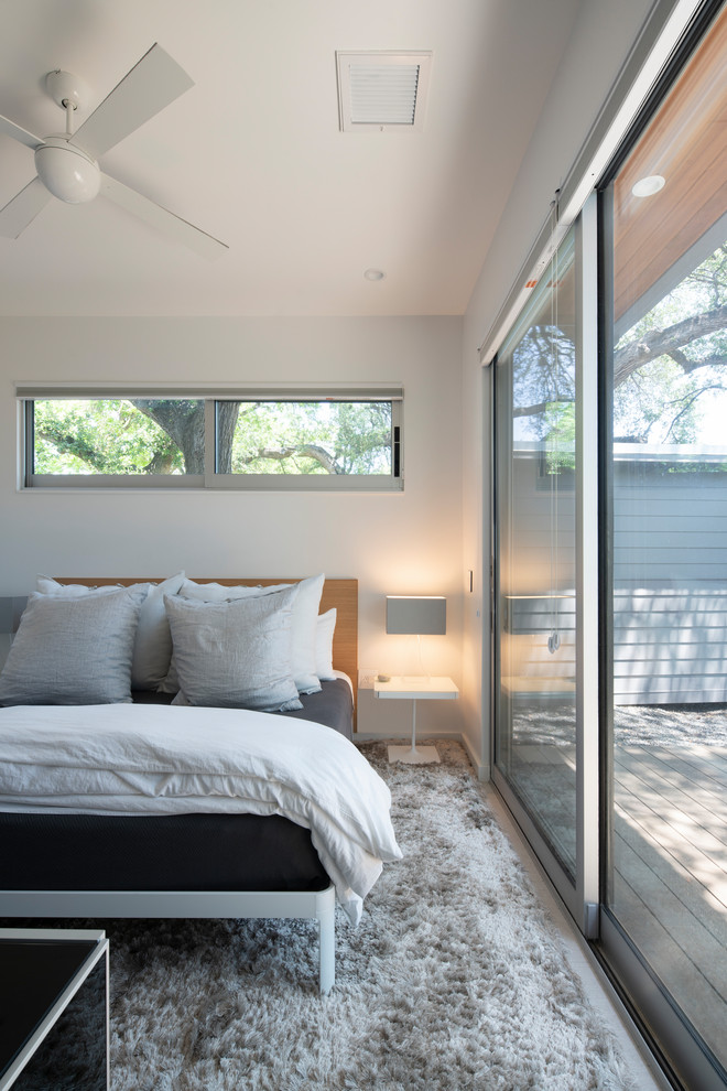 This is an example of a mid-sized modern master bedroom in Austin with white walls, porcelain floors and grey floor.