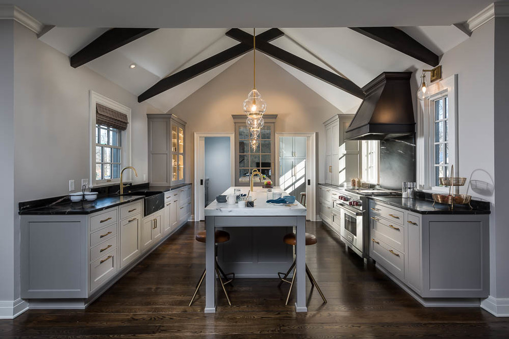 Large transitional kitchen in Other with a farmhouse sink, recessed-panel cabinets, grey cabinets, soapstone benchtops, stainless steel appliances, dark hardwood floors, with island and brown floor.