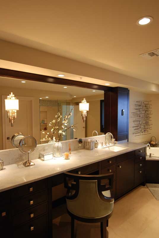 This is an example of a large transitional master bathroom in Miami with flat-panel cabinets, dark wood cabinets, quartzite benchtops, a corner tub, an alcove shower, a two-piece toilet, beige tile, mosaic tile, beige walls, limestone floors and an undermount sink.