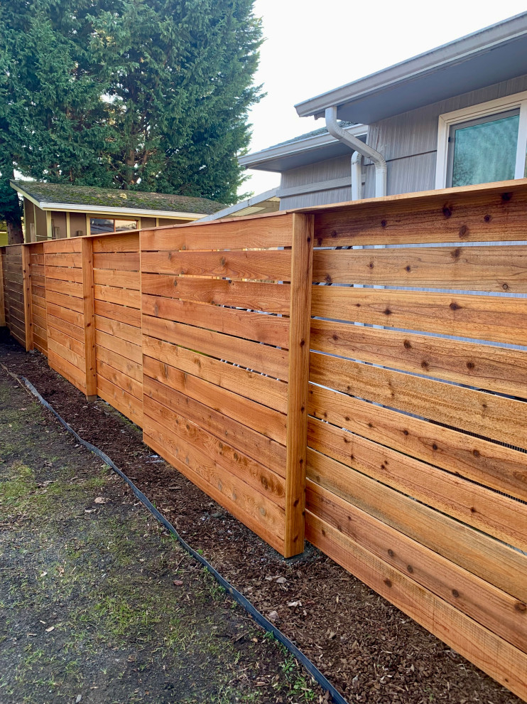 Exemple d'un petit jardin arrière moderne avec des solutions pour vis-à-vis et une clôture en bois.