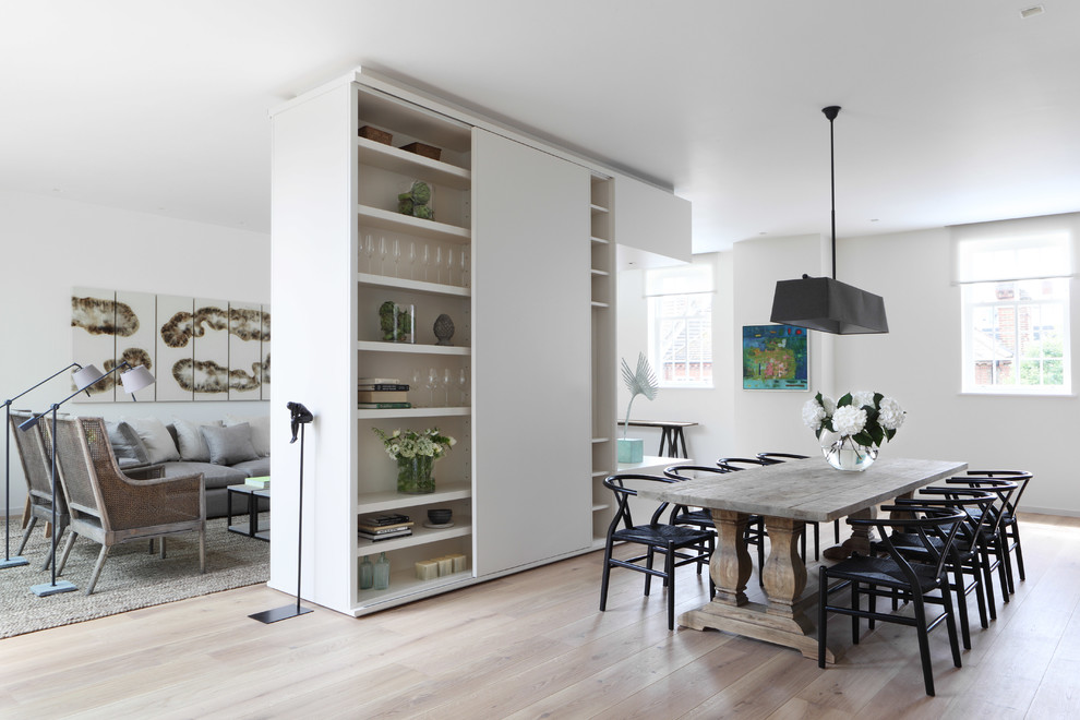 Photo of a contemporary open plan dining in London with white walls and light hardwood floors.