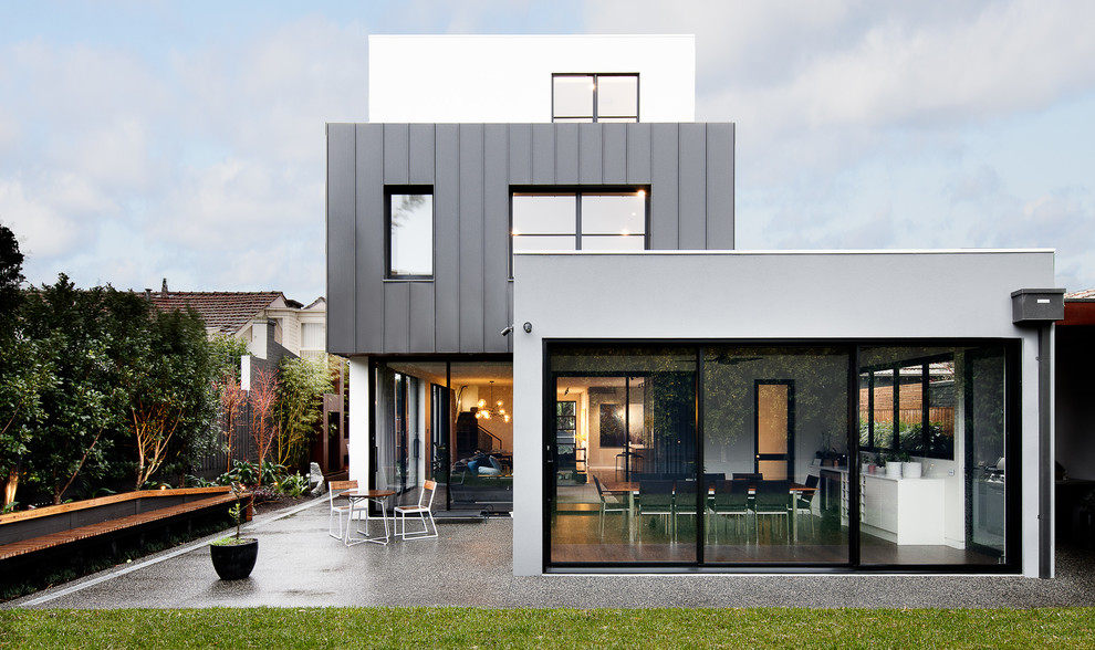 Inspiration for a large contemporary three-storey grey house exterior in Melbourne with mixed siding, a flat roof and a metal roof.