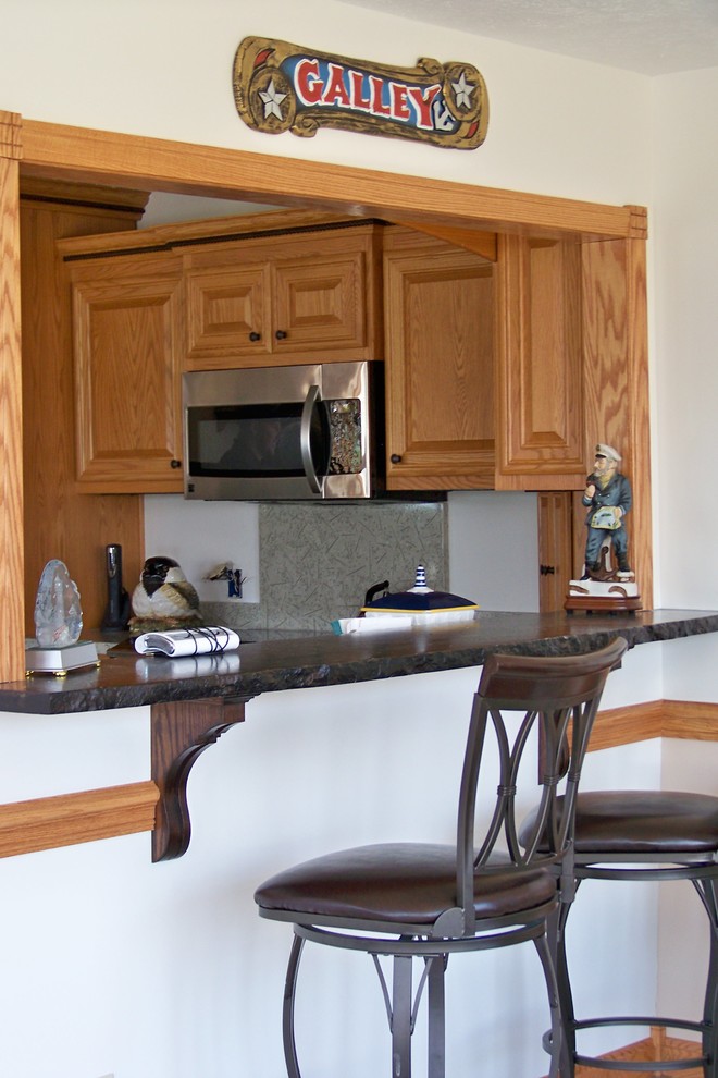 Example of a medium tone wood floor kitchen design with a double-bowl sink, medium tone wood cabinets, granite countertops, beige backsplash and stainless steel appliances
