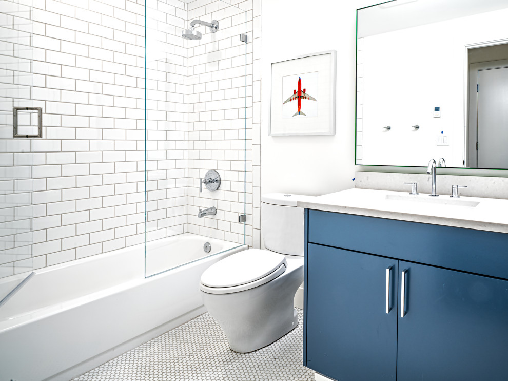 Design ideas for a contemporary kids bathroom in Seattle with flat-panel cabinets, blue cabinets, an alcove tub, a shower/bathtub combo, a two-piece toilet, white tile, subway tile, white walls, mosaic tile floors, an undermount sink, white floor, a hinged shower door, white benchtops, a single vanity and a floating vanity.