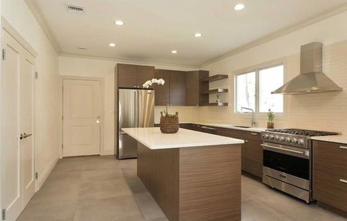 Contemporary kitchen with walnut-look flat-panel cabinets, white quartz island, stainless steel range and fridge