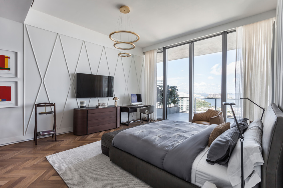 This is an example of a contemporary bedroom in Miami with grey walls, medium hardwood floors and brown floor.