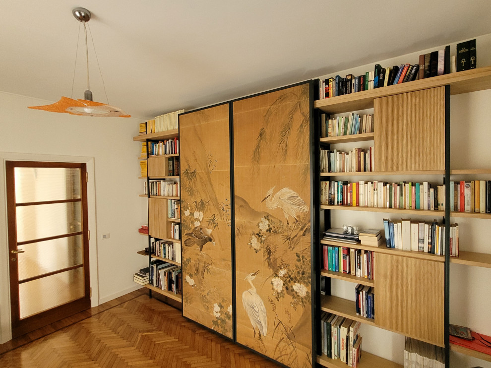 Aménagement d'un bureau rétro de taille moyenne avec une bibliothèque ou un coin lecture et parquet clair.