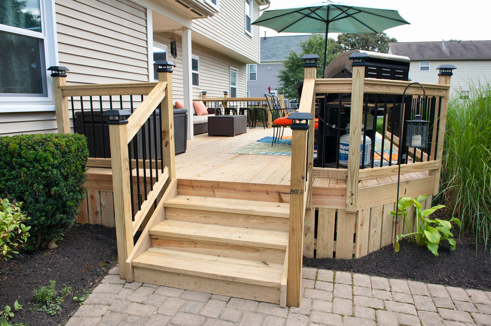 Example of a mid-sized minimalist backyard deck design in Columbus with no cover