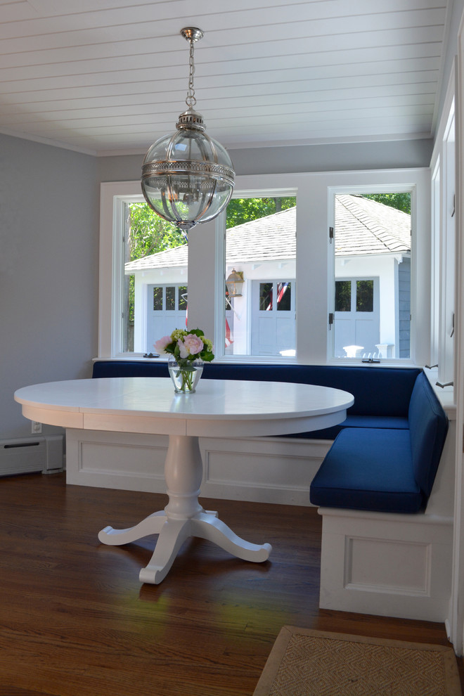 Example of a mid-sized transitional u-shaped dark wood floor eat-in kitchen design in New York with a farmhouse sink, recessed-panel cabinets, white cabinets, quartz countertops, white backsplash, subway tile backsplash, stainless steel appliances and an island