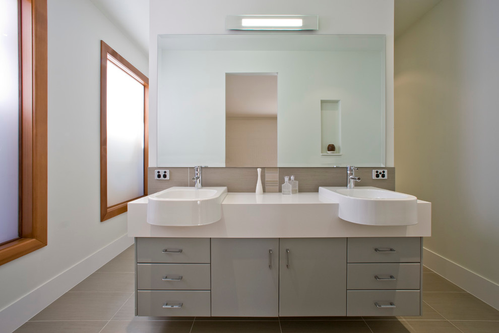 This is an example of a mid-sized asian master bathroom in Melbourne with a console sink, flat-panel cabinets, grey cabinets, engineered quartz benchtops, an open shower, a two-piece toilet, gray tile, porcelain tile, white walls and porcelain floors.