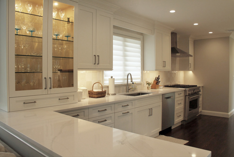 Idéer för små vitt kök, med en undermonterad diskho, luckor med glaspanel, vita skåp, bänkskiva i kvarts, vitt stänkskydd, stänkskydd i keramik, rostfria vitvaror, mörkt trägolv, en halv köksö och brunt golv