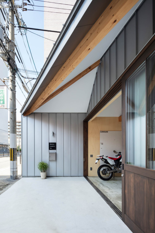 This is an example of a small industrial entry hall in Osaka with grey walls, a sliding front door, a dark wood front door, grey floor, recessed and panelled walls.