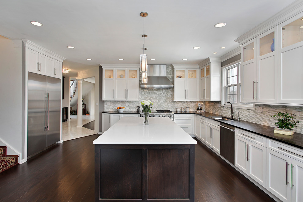 Transitional l-shaped dark wood floor kitchen photo in Chicago with an undermount sink, shaker cabinets, stainless steel appliances, an island, white cabinets, multicolored backsplash and mosaic tile backsplash