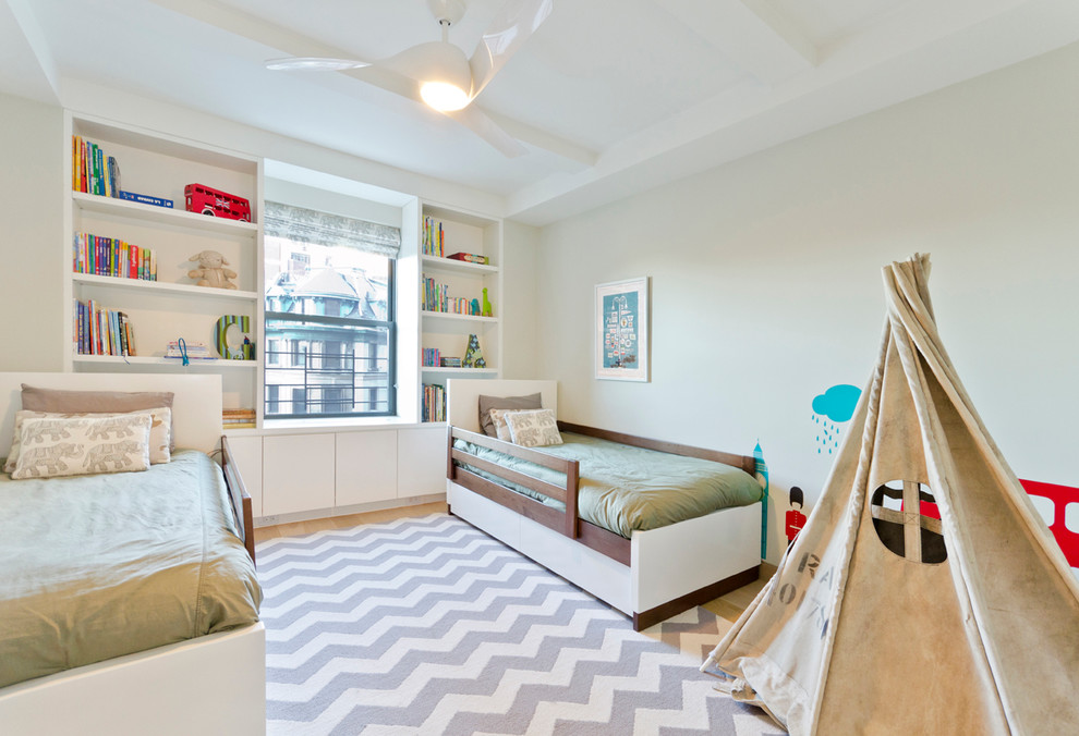 Photo of a contemporary gender-neutral kids' bedroom for kids 4-10 years old in New York with light hardwood floors.