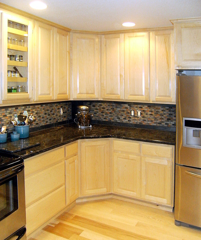 Kitchen - brown floor kitchen idea with raised-panel cabinets and stainless steel appliances