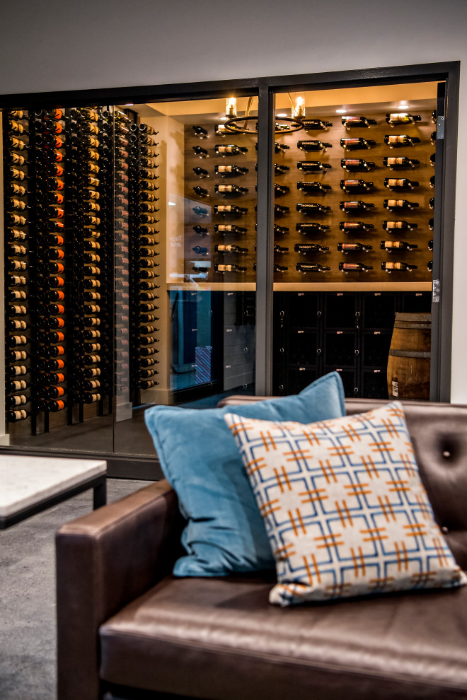 Photo of a large transitional wine cellar in Denver with concrete floors and display racks.