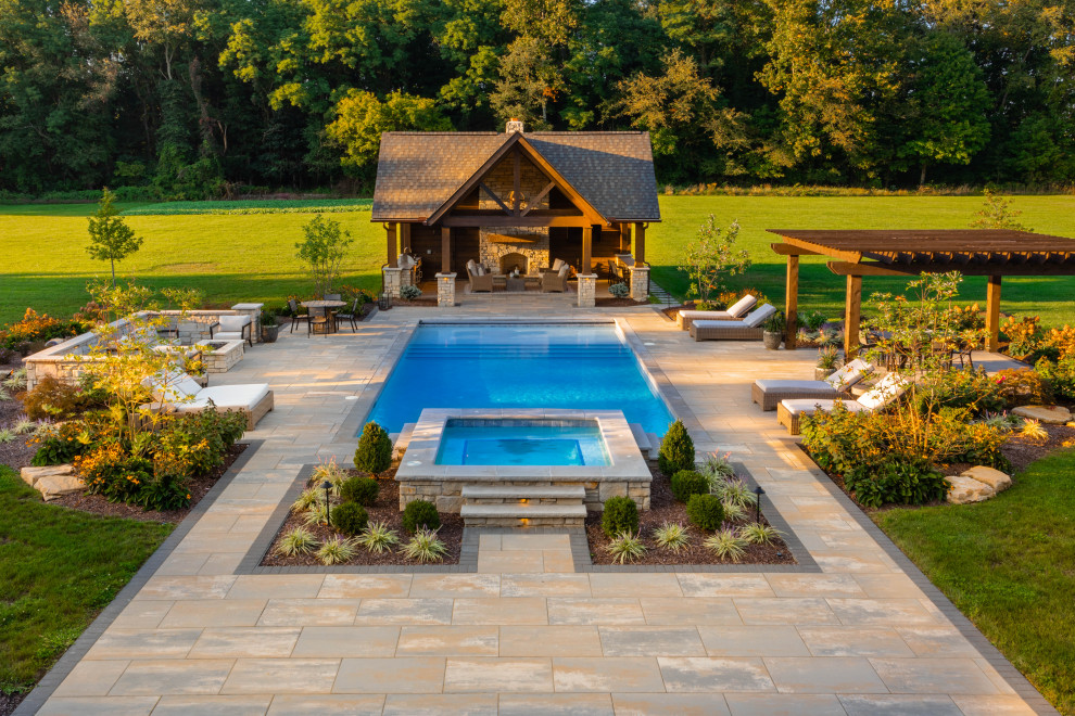 Idee per una piscina american style rettangolare dietro casa con una dépendance a bordo piscina e pavimentazioni in pietra naturale