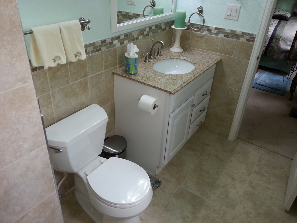 Mid-sized transitional 3/4 beige tile and porcelain tile porcelain tile and beige floor alcove shower photo with raised-panel cabinets, white cabinets, a two-piece toilet, blue walls, an undermount sink, laminate countertops, a hinged shower door and multicolored countertops