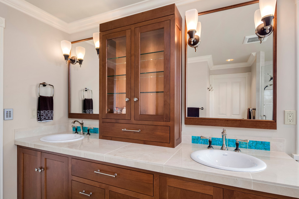 Design ideas for a large transitional master bathroom in Seattle with shaker cabinets, brown cabinets, a freestanding tub, an open shower, a one-piece toilet, beige tile, marble, beige walls, marble floors, a drop-in sink, tile benchtops, brown floor and a hinged shower door.