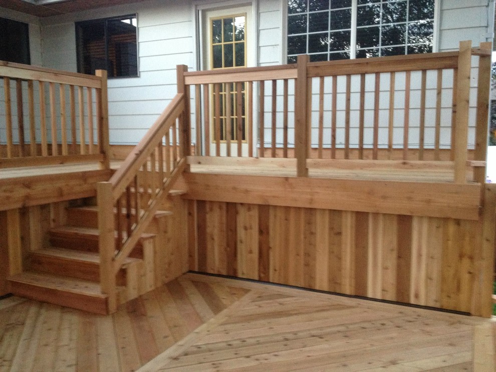 Example of a large backyard deck design in Vancouver with a pergola