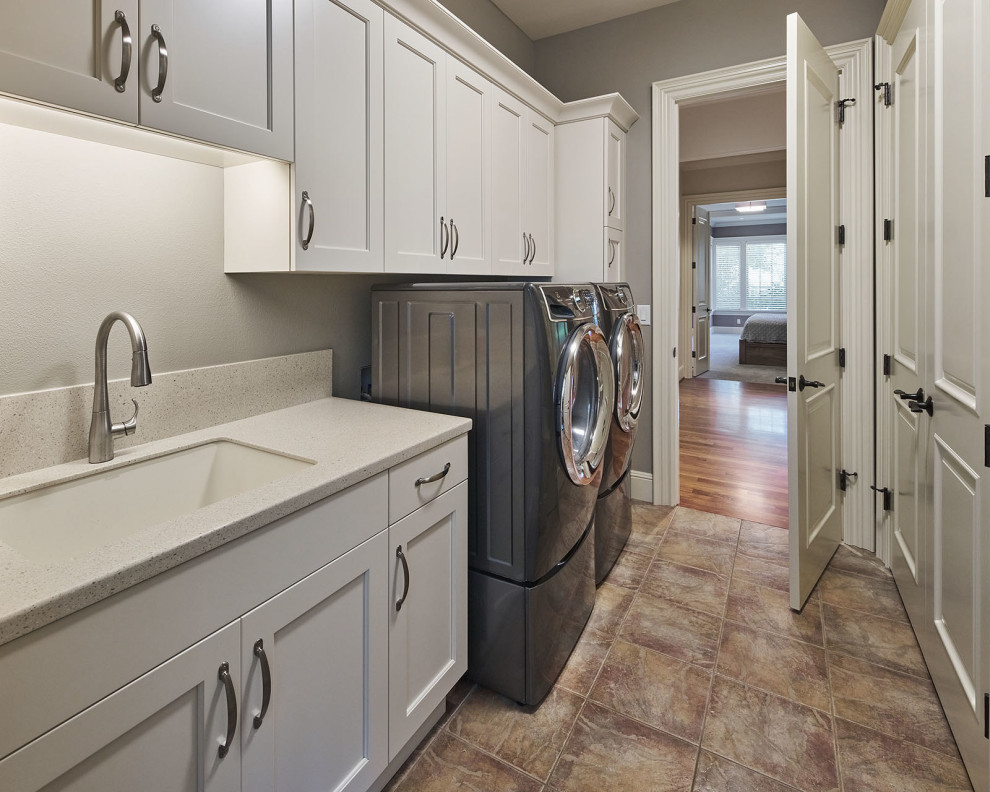 Large farmhouse single-wall separated utility room in Portland with a submerged sink, shaker cabinets, white cabinets, grey walls, ceramic flooring, a side by side washer and dryer, multi-coloured floors and beige worktops.