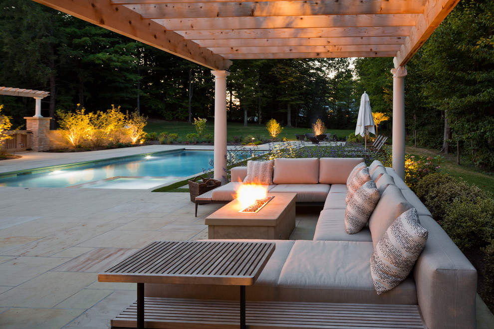 Traditional patio in Cleveland with a fire feature, natural stone pavers and a pergola.
