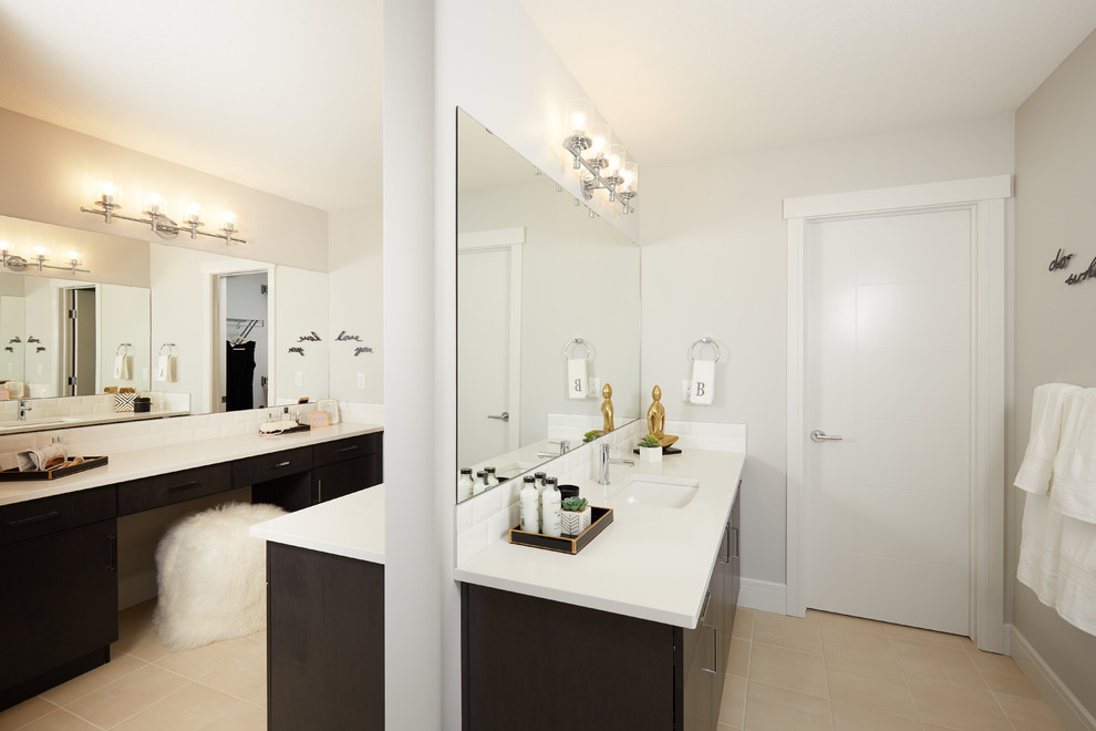 Photo of a large transitional master bathroom in Edmonton with flat-panel cabinets, black cabinets, a drop-in tub, an open shower, a one-piece toilet, white tile, ceramic tile, grey walls, cement tiles, an undermount sink, engineered quartz benchtops, beige floor and a hinged shower door.