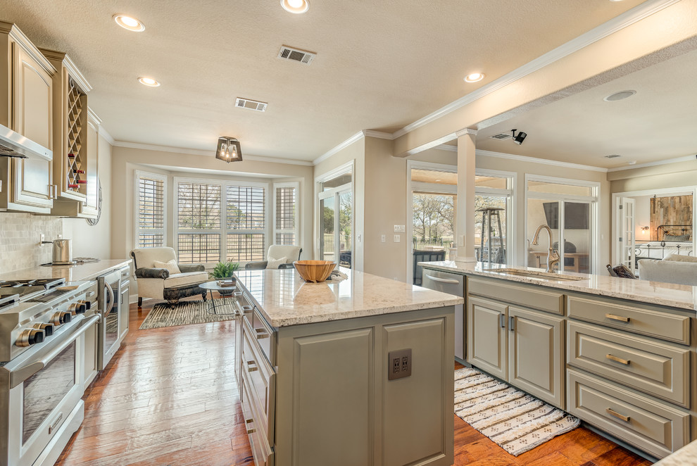 Mid-sized transitional kitchen in Austin with an undermount sink, raised-panel cabinets, green cabinets, granite benchtops, stainless steel appliances, medium hardwood floors, with island and white benchtop.