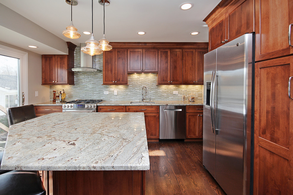 Mid-sized transitional l-shaped dark wood floor eat-in kitchen photo in Chicago with a single-bowl sink, shaker cabinets, medium tone wood cabinets, granite countertops, green backsplash, glass tile backsplash, stainless steel appliances and an island