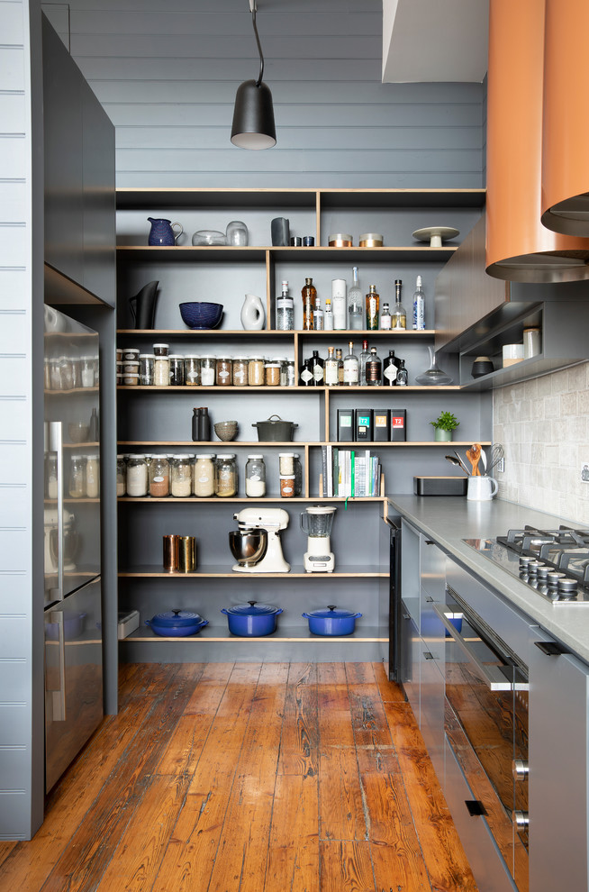 Photo of a mid-sized contemporary u-shaped eat-in kitchen in Melbourne with a double-bowl sink, flat-panel cabinets, grey cabinets, quartz benchtops, grey splashback, ceramic splashback, stainless steel appliances, medium hardwood floors, with island, brown floor and grey benchtop.