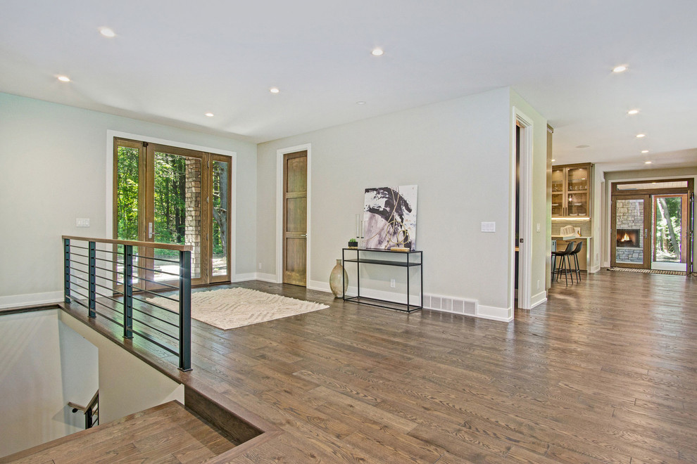 Example of a mountain style dark wood floor and brown floor foyer design in Grand Rapids with a glass front door