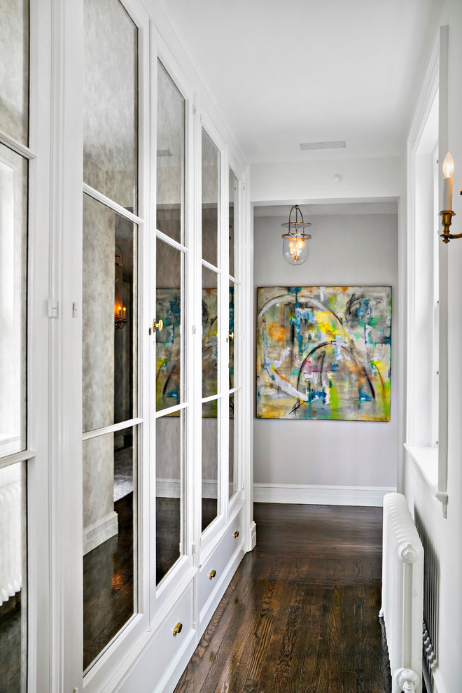 This is an example of a mid-sized transitional hallway in New York with grey walls and dark hardwood floors.