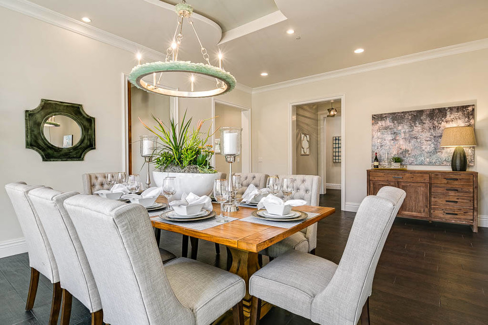 This is an example of a beach style dining room in Los Angeles with beige walls, dark hardwood floors and beige floor.