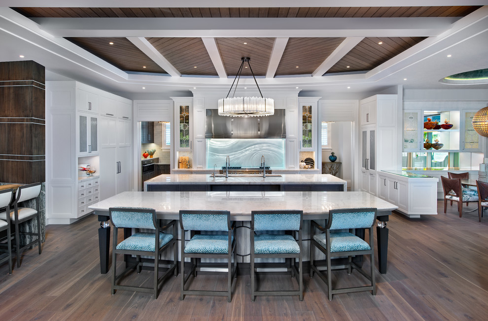 Design ideas for a beach style open plan kitchen in Miami with an undermount sink, shaker cabinets, white cabinets, stainless steel appliances, dark hardwood floors, multiple islands, brown floor and white benchtop.