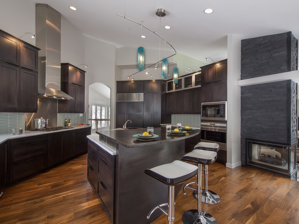 Contemporary kitchen in Denver with shaker cabinets, dark wood cabinets, marble benchtops, blue splashback, glass tile splashback and stainless steel appliances.