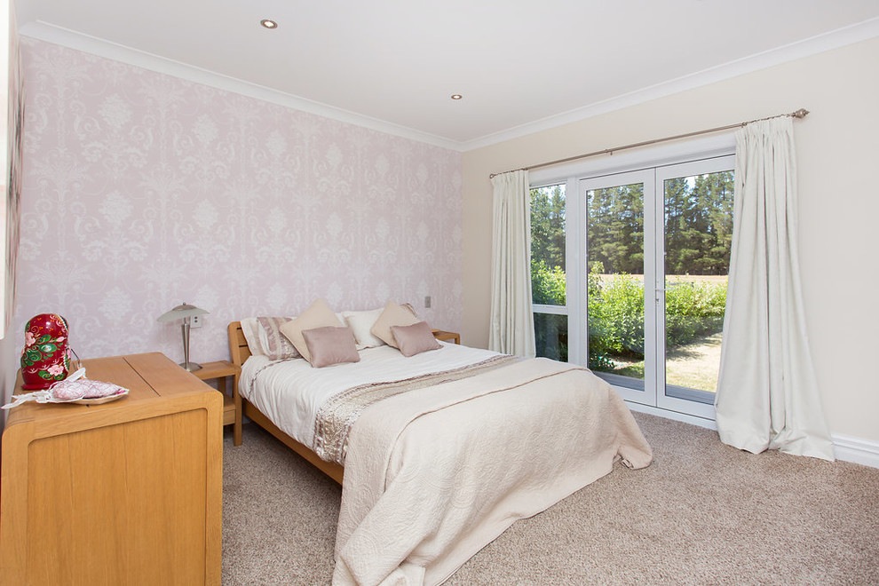 Mid-sized country Guest bedroom in Christchurch With Pink Walls, Carpet and Grey Floor.