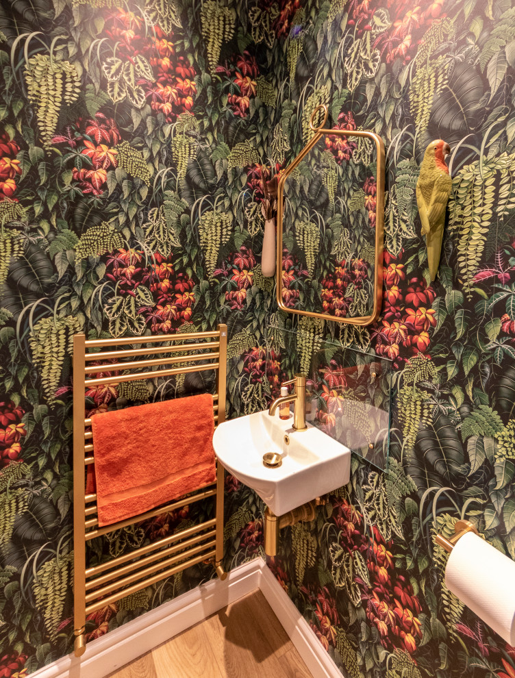This is an example of a small contemporary powder room in Surrey with green walls, vinyl floors and wallpaper.