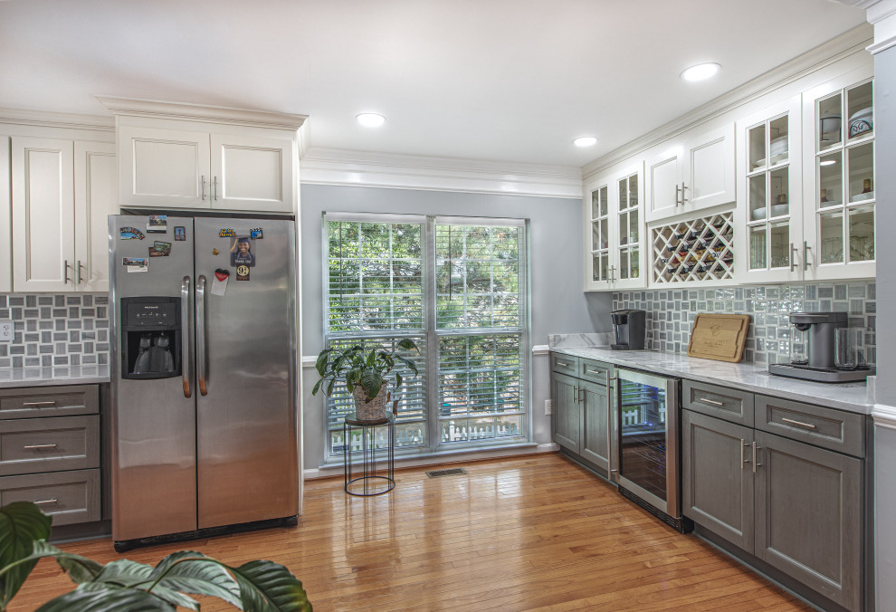 Inspiration for a large contemporary galley laminate floor and multicolored floor eat-in kitchen remodel in DC Metro with an undermount sink, shaker cabinets, dark wood cabinets, marble countertops, white backsplash, stainless steel appliances, a peninsula and white countertops