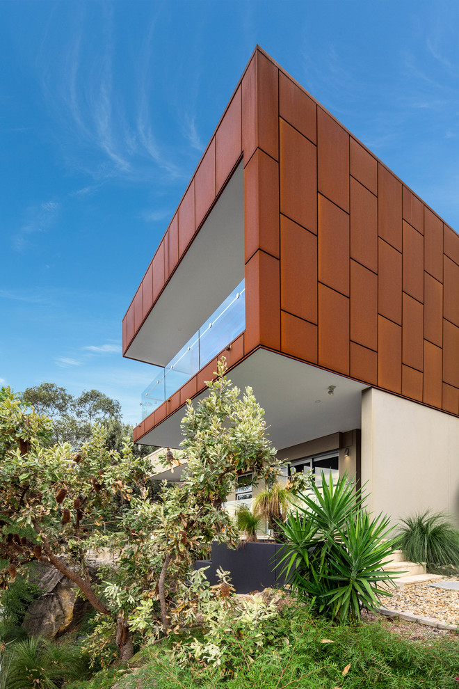 Photo of a large contemporary three-storey exterior in Sydney with metal siding and a flat roof.