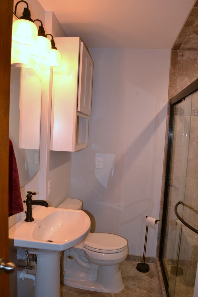 Small transitional 3/4 gray tile and porcelain tile porcelain tile alcove shower photo with a pedestal sink, recessed-panel cabinets, white cabinets, a two-piece toilet and gray walls