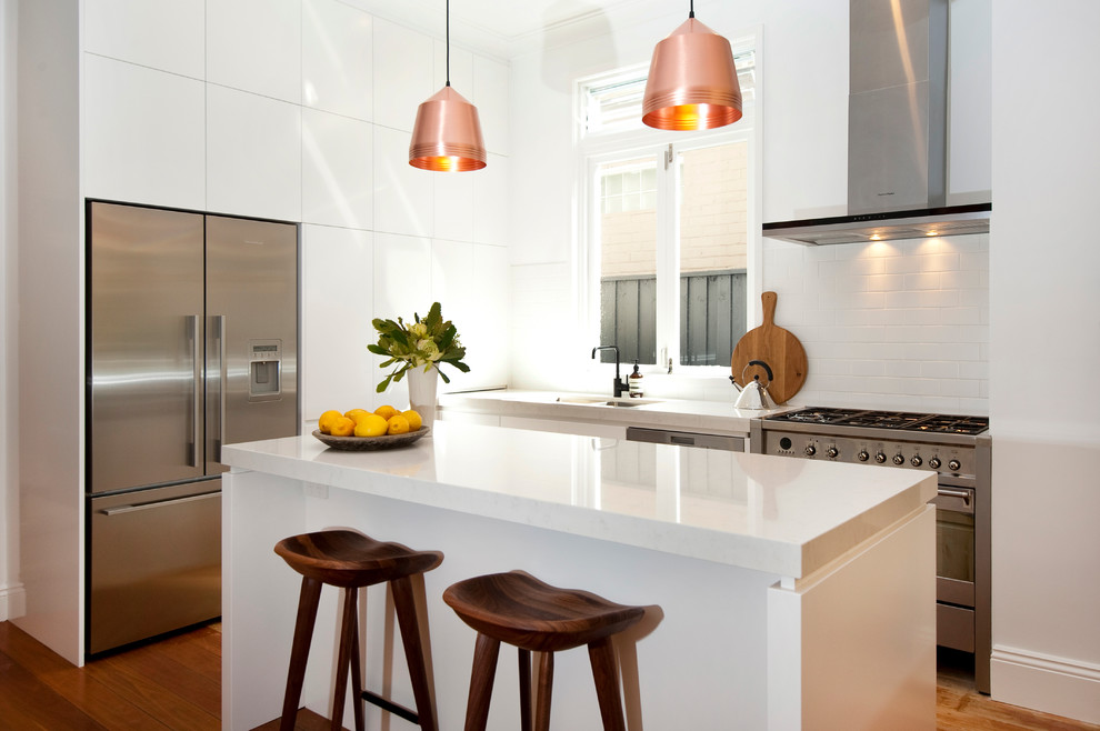 Inspiration for a contemporary kitchen in Sydney with white splashback and with island.