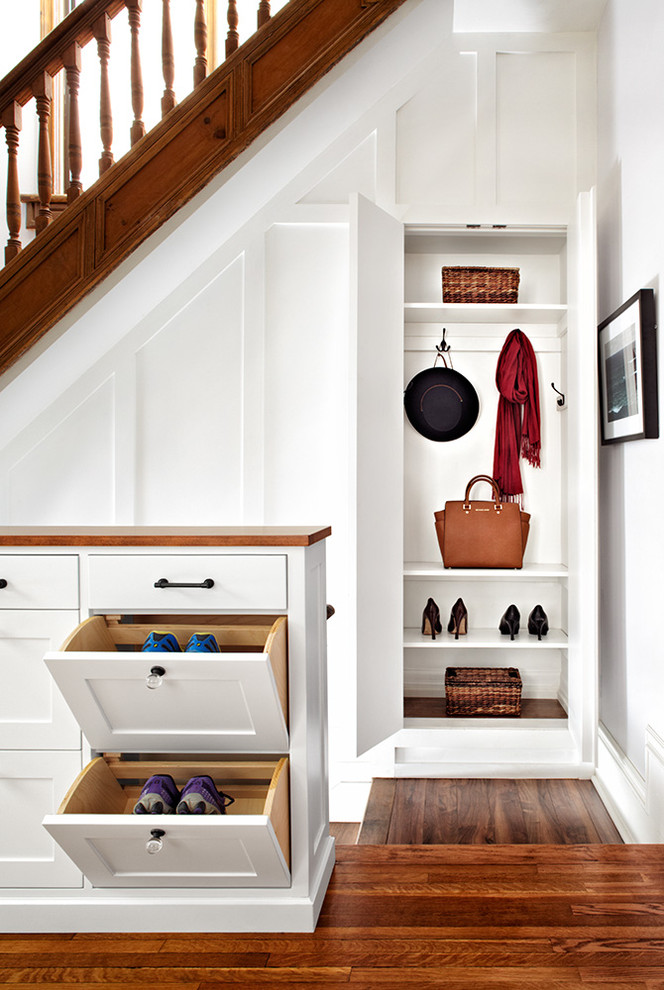 Design ideas for a transitional gender-neutral built-in wardrobe in Toronto with shaker cabinets, white cabinets and medium hardwood floors.