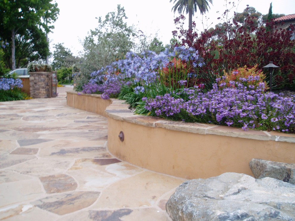 Design ideas for a mediterranean patio in San Diego with natural stone pavers.