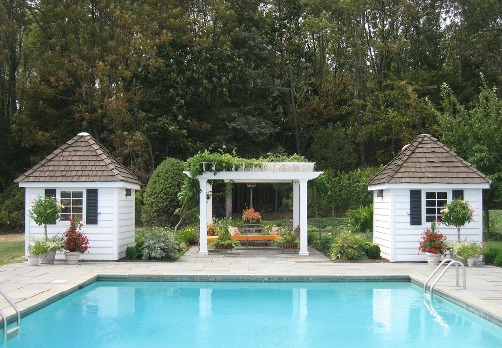 Design ideas for a large traditional backyard rectangular pool in New York with natural stone pavers and a pool house.
