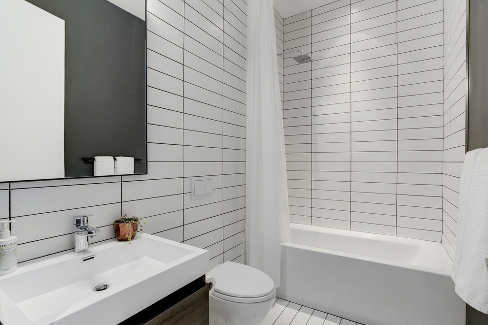 Inspiration for a contemporary bathroom in DC Metro with flat-panel cabinets, dark wood cabinets, a freestanding tub, a wall-mount toilet, black and white tile, ceramic tile, white walls, ceramic floors, a vessel sink, engineered quartz benchtops and an alcove shower.