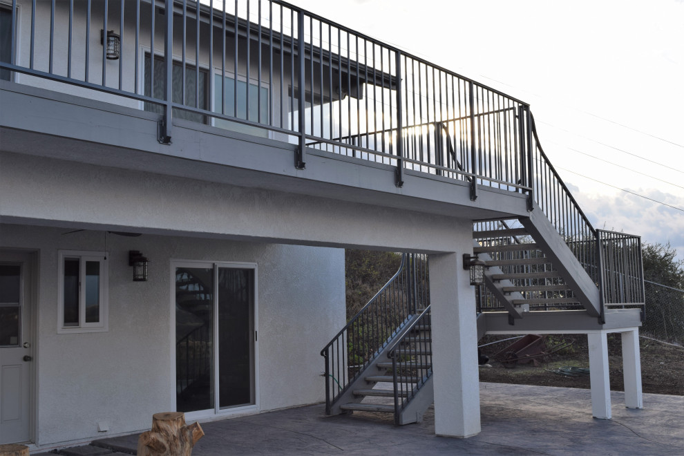 Foto di una grande privacy sulla terrazza minimal dietro casa e al primo piano con un tetto a sbalzo e parapetto in metallo