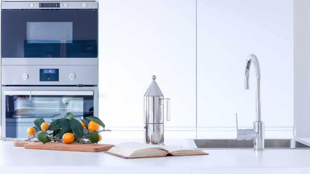 Immagine di una grande cucina design con lavello da incasso, ante lisce, ante bianche, top in laminato, elettrodomestici in acciaio inossidabile, pavimento in gres porcellanato, pavimento grigio, top bianco e soffitto ribassato